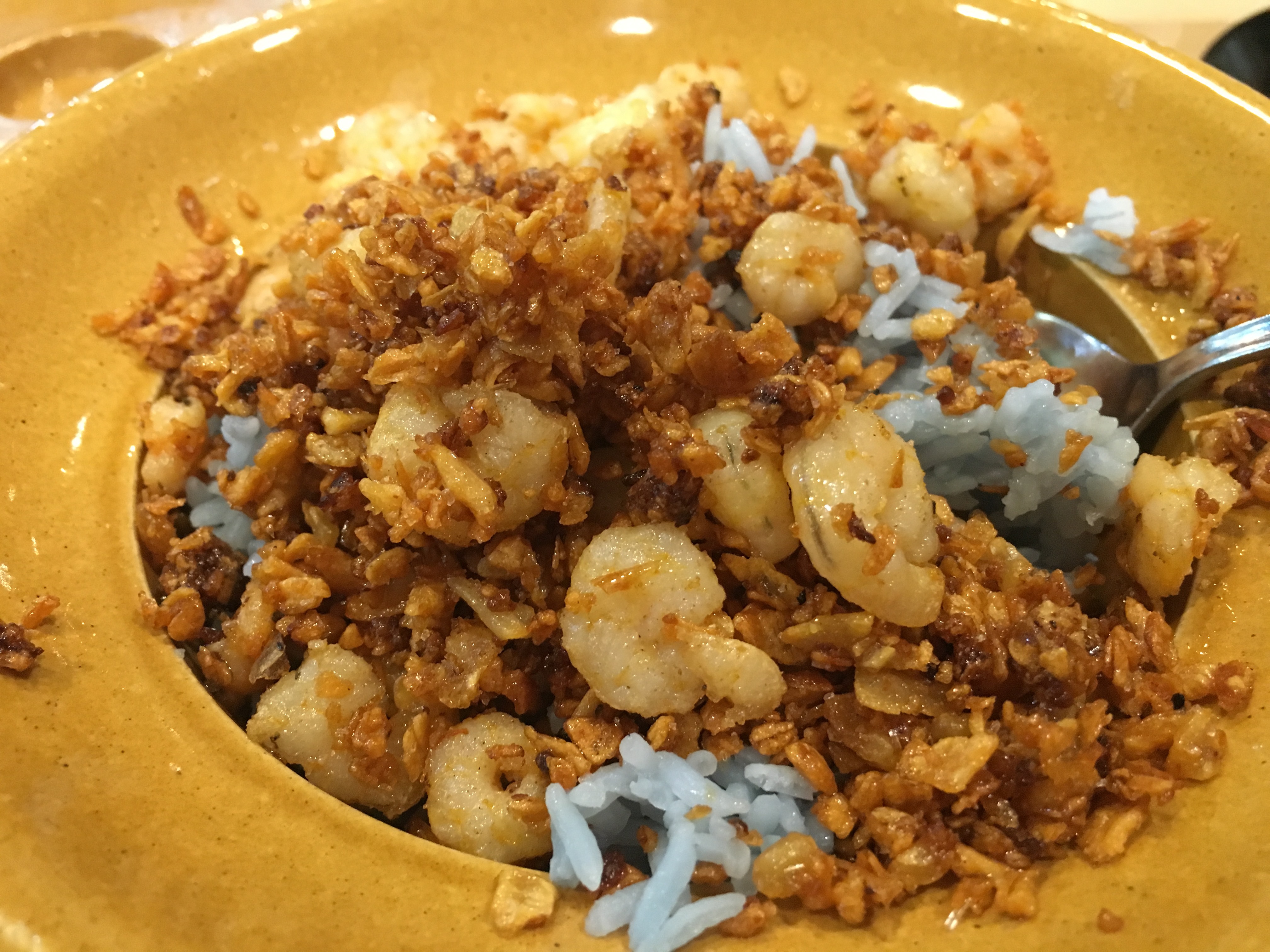 実際に食べた76バーツの料理。青いご飯の上にエビとガーリック炒め