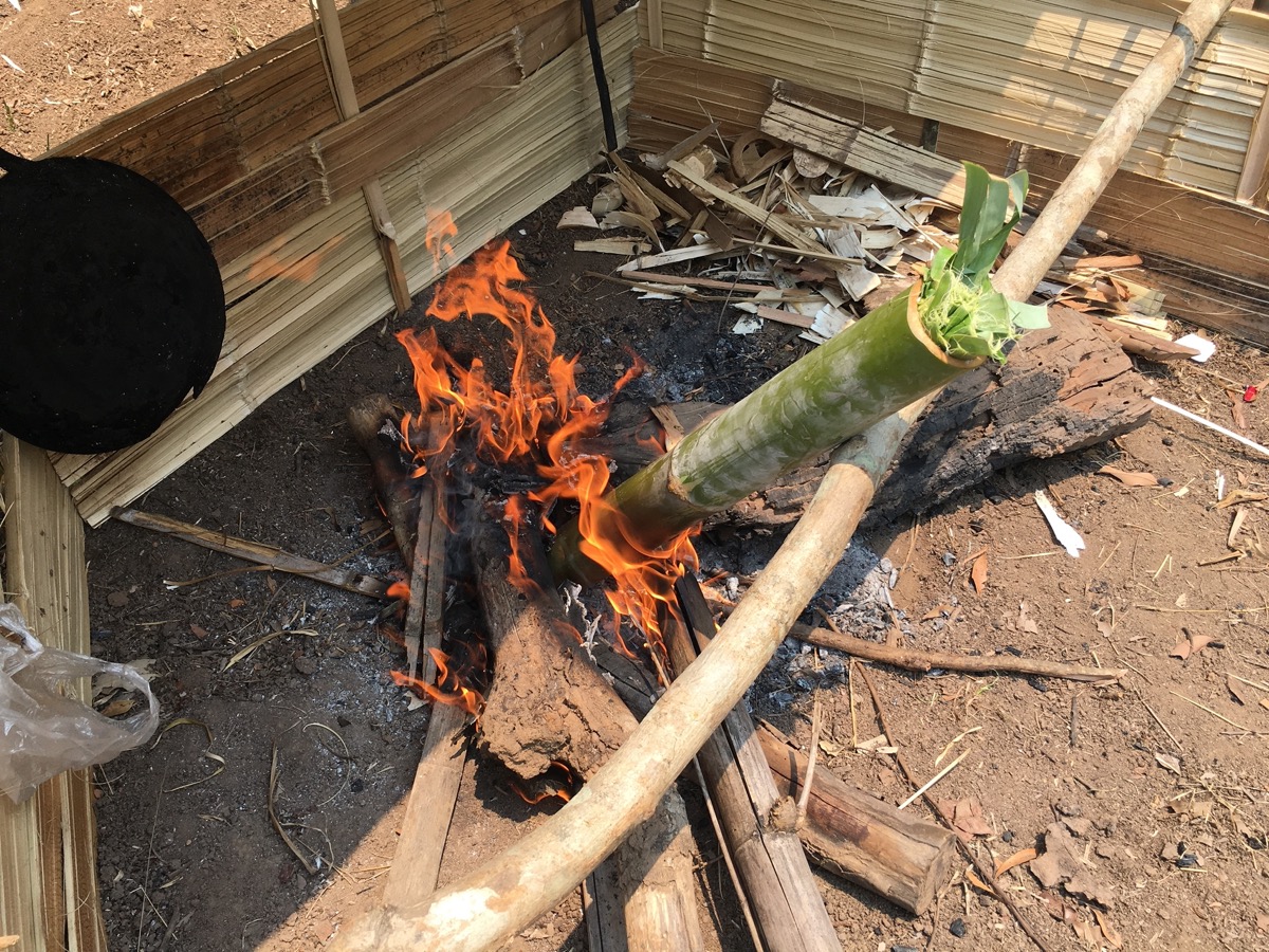 竹を使ってごはんを炊く。火にかけた竹筒の中でもち米が炊き上がる