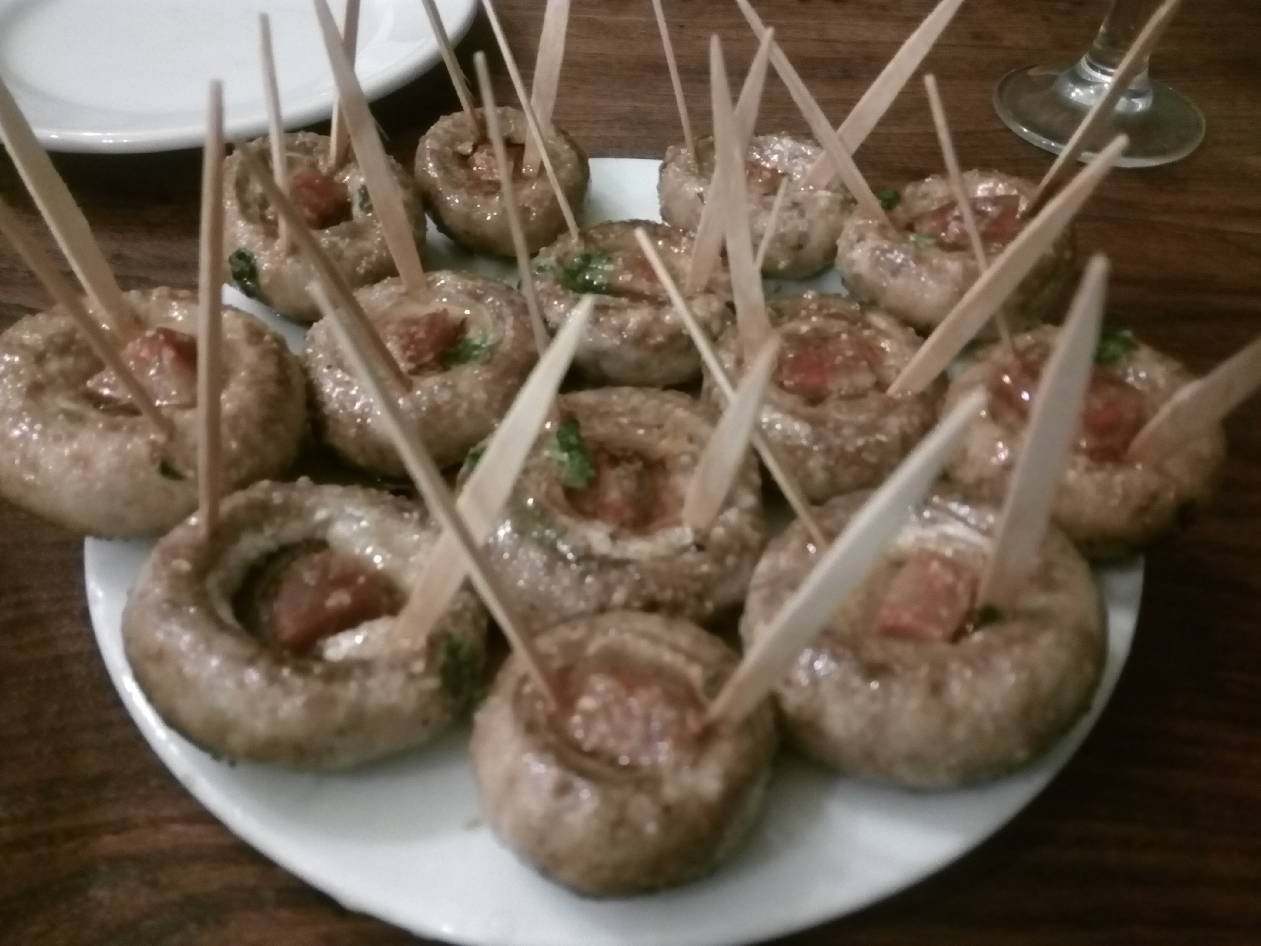 楊枝が刺さったマッシュルームの鉄板焼きのタパス