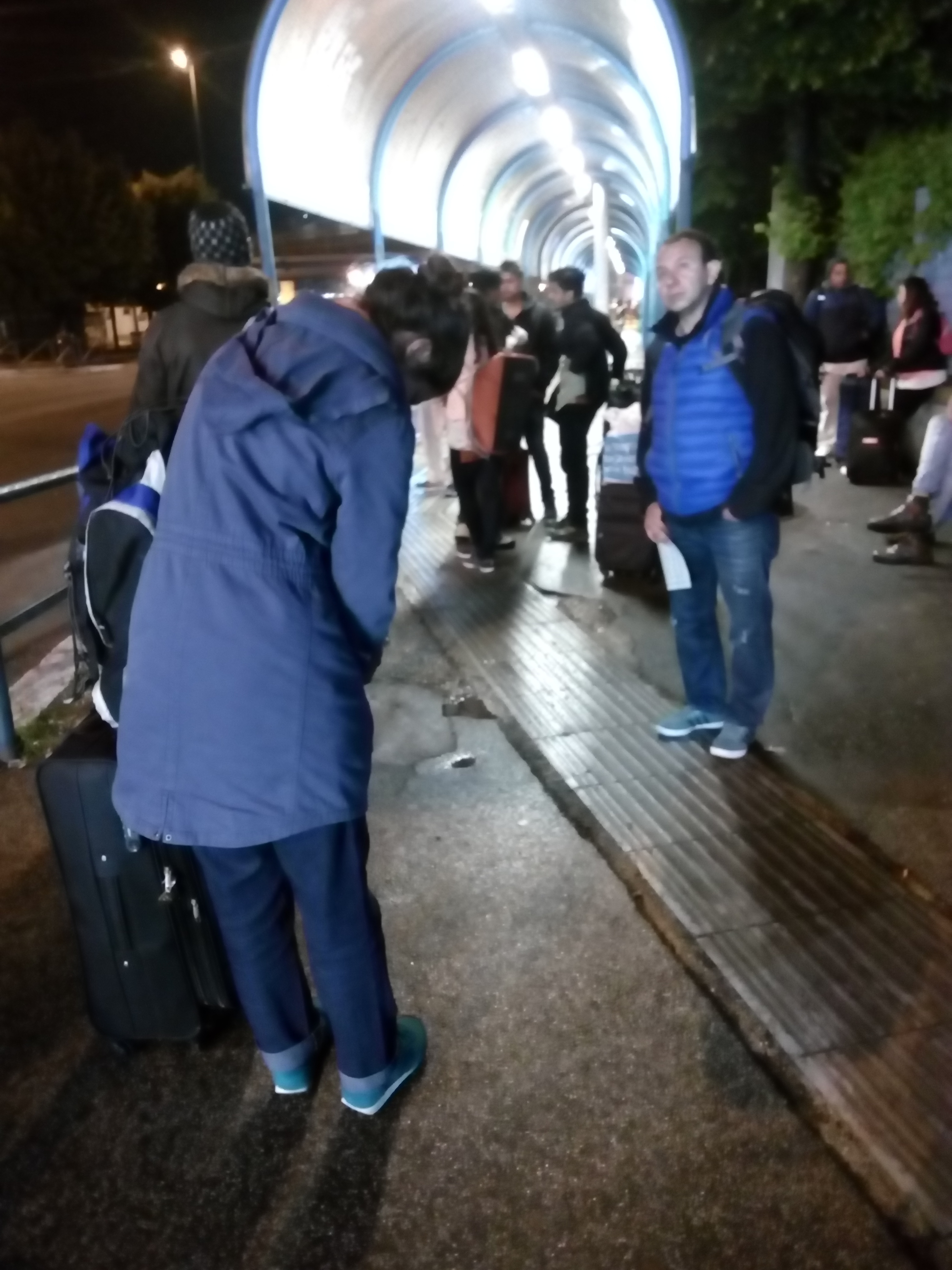深夜、バス停の外で待つヴェネチア行きの乗客たち