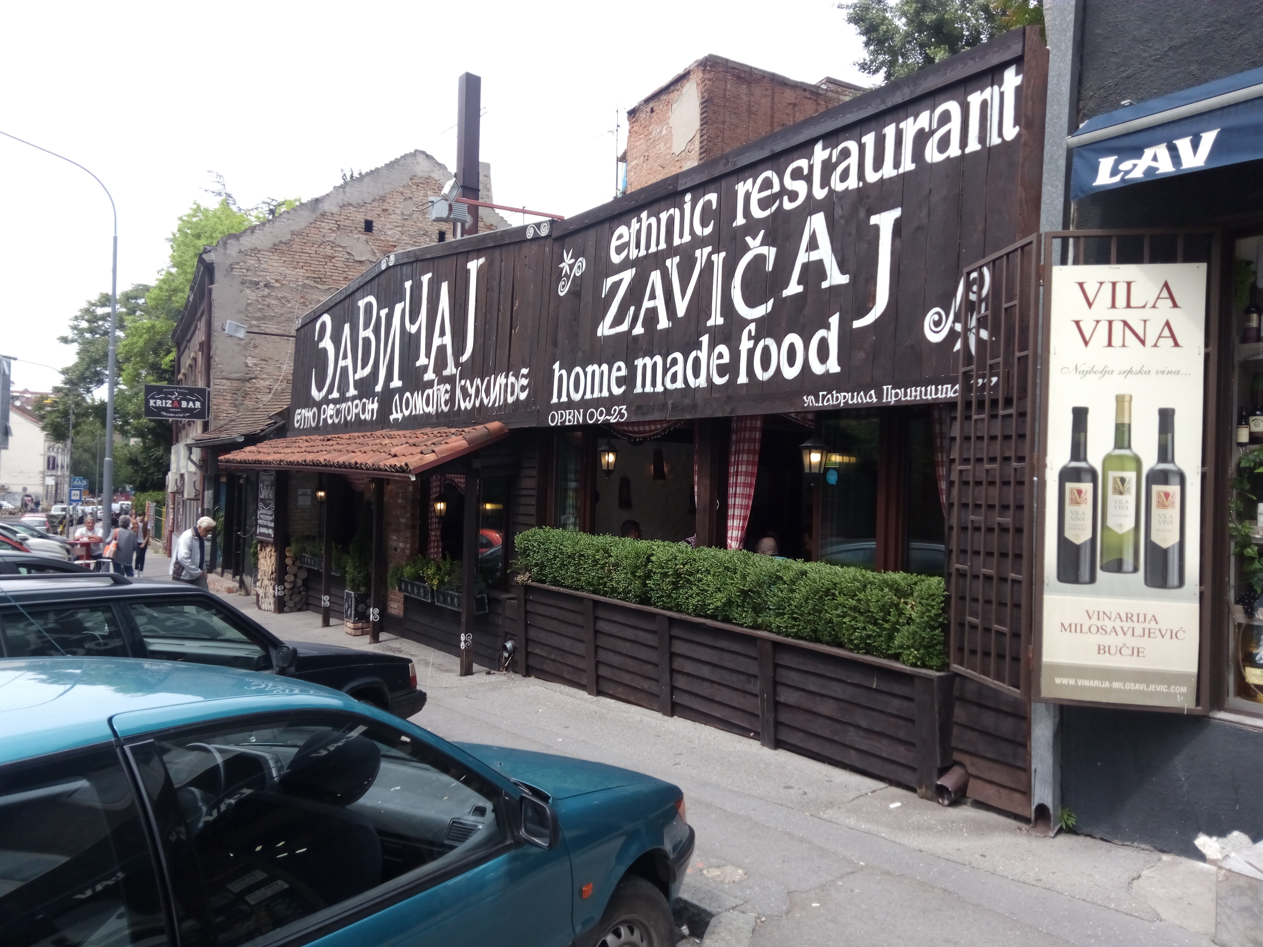 Zavicajの外観。木造の重厚な看板に「ethnic restaurant」「home made food」の文字